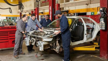 students working on a car