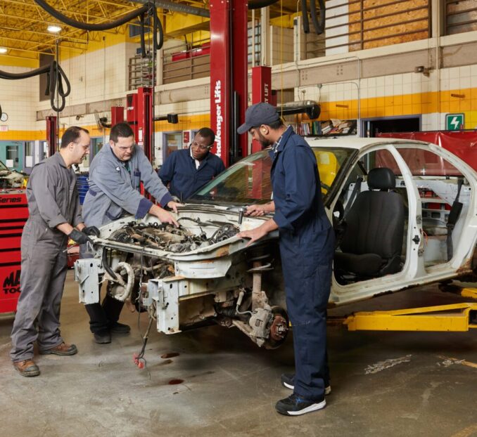 students working on a car