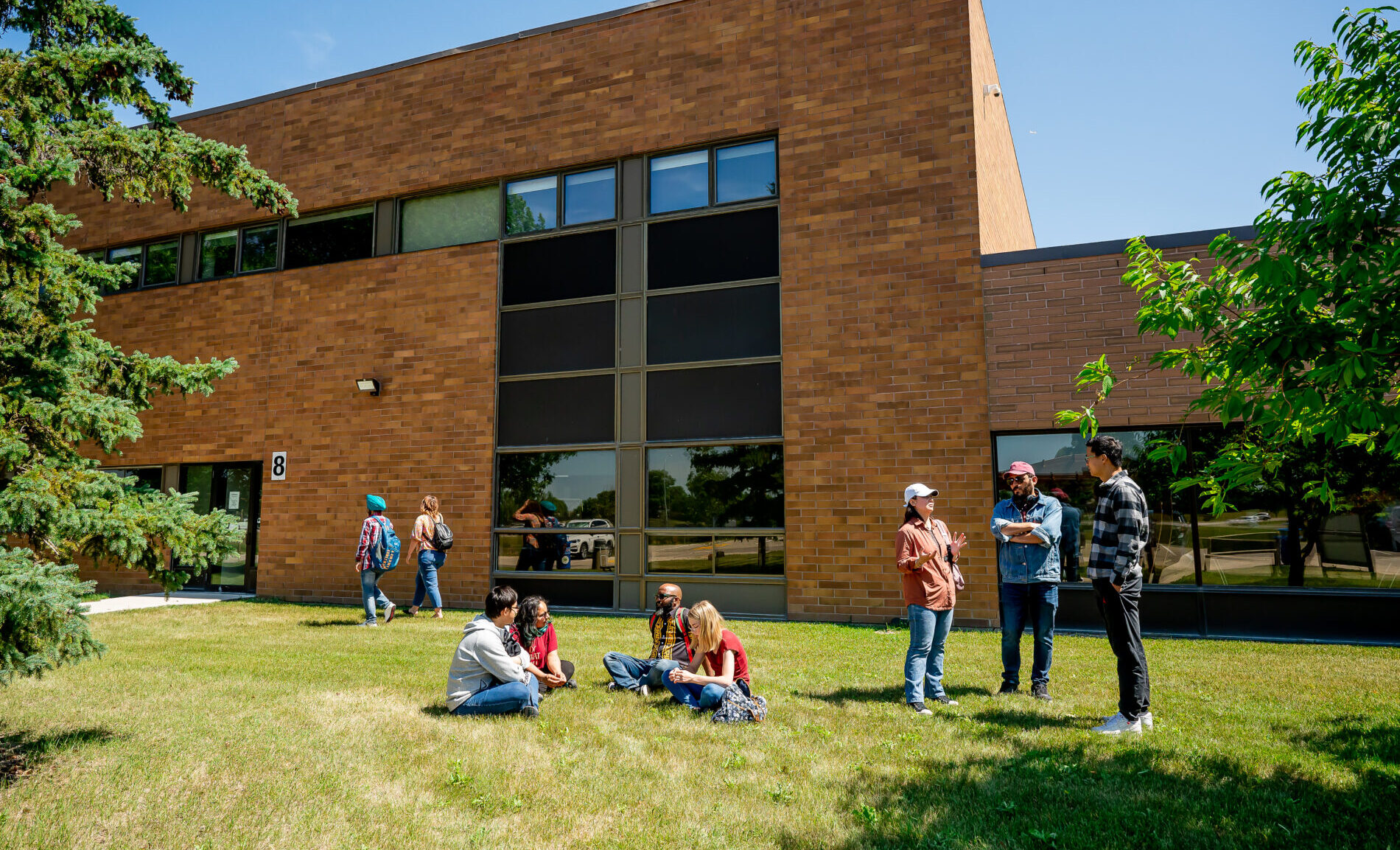 Students sitting and talking to each other outside campus building