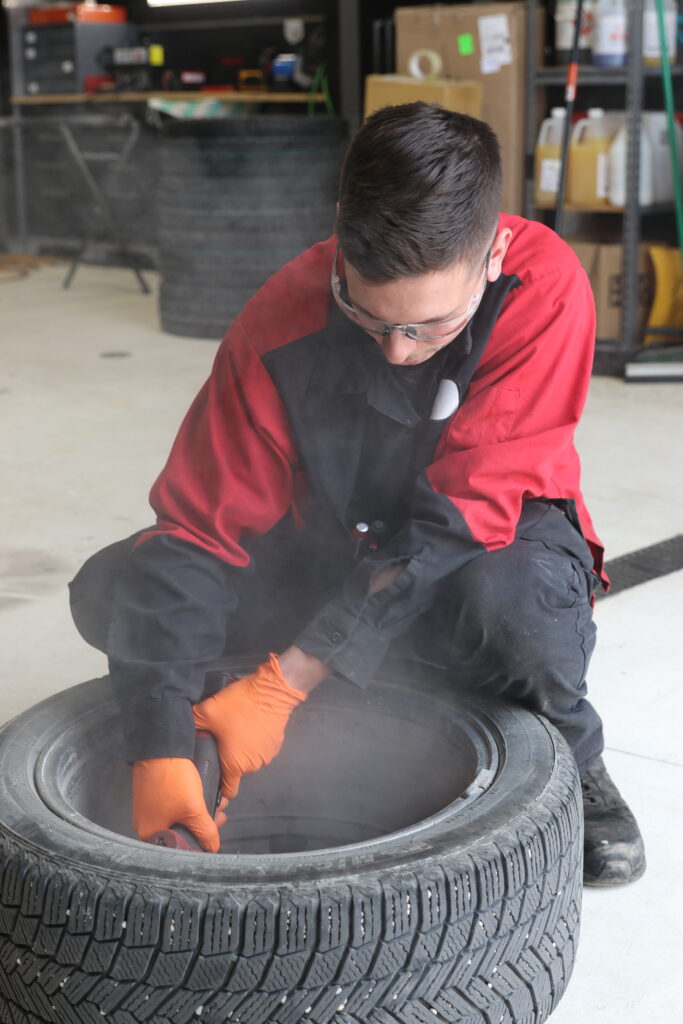 Alumni working on a tire