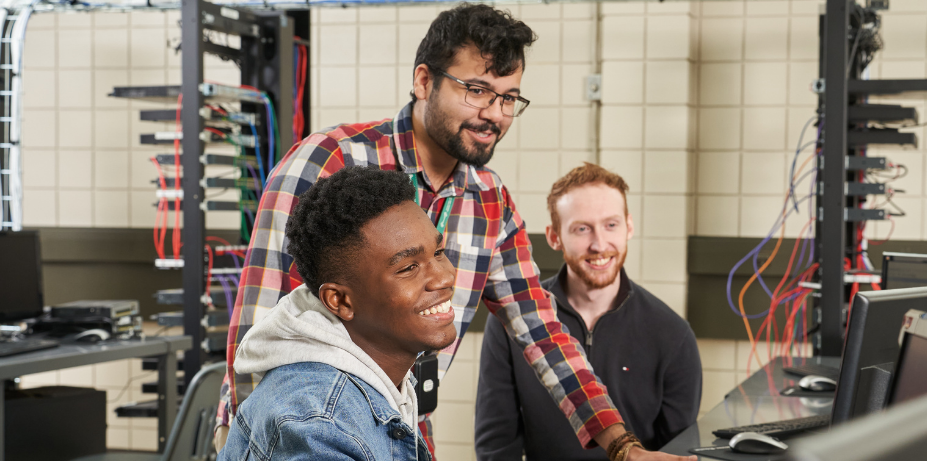 Students smiling while working in server room