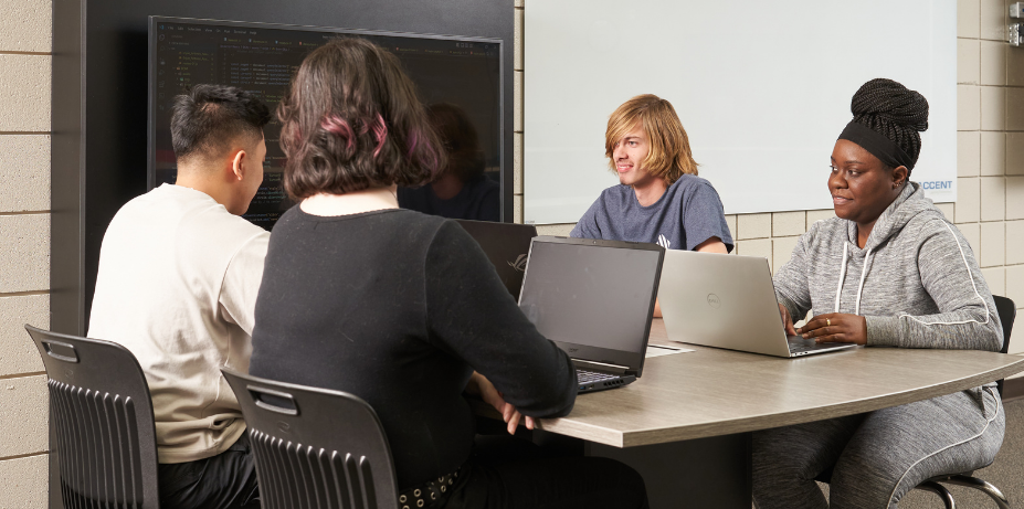 Students working on laptops at a table