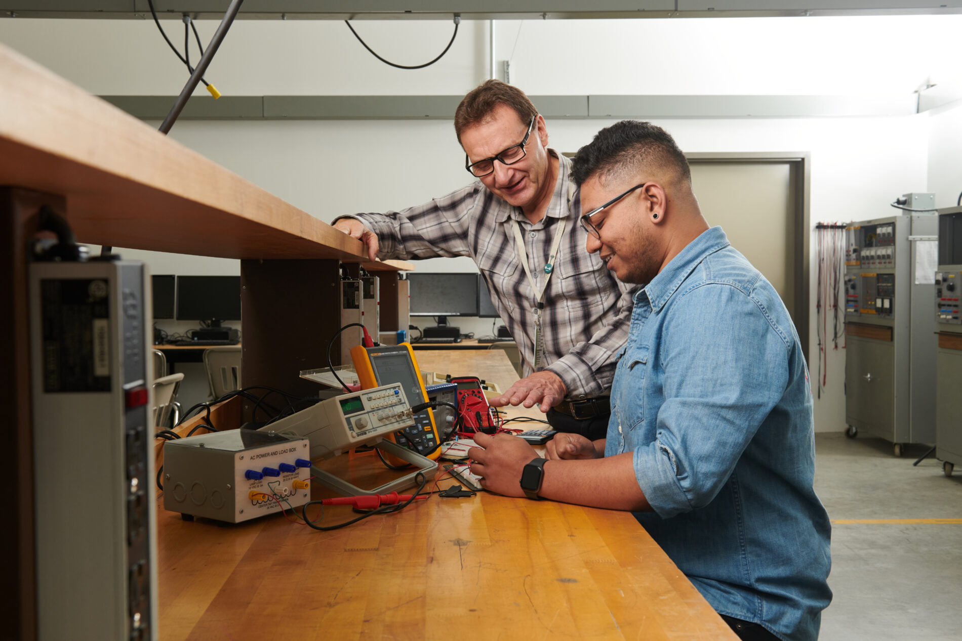 instructor showing student how to work on an electronic appliance