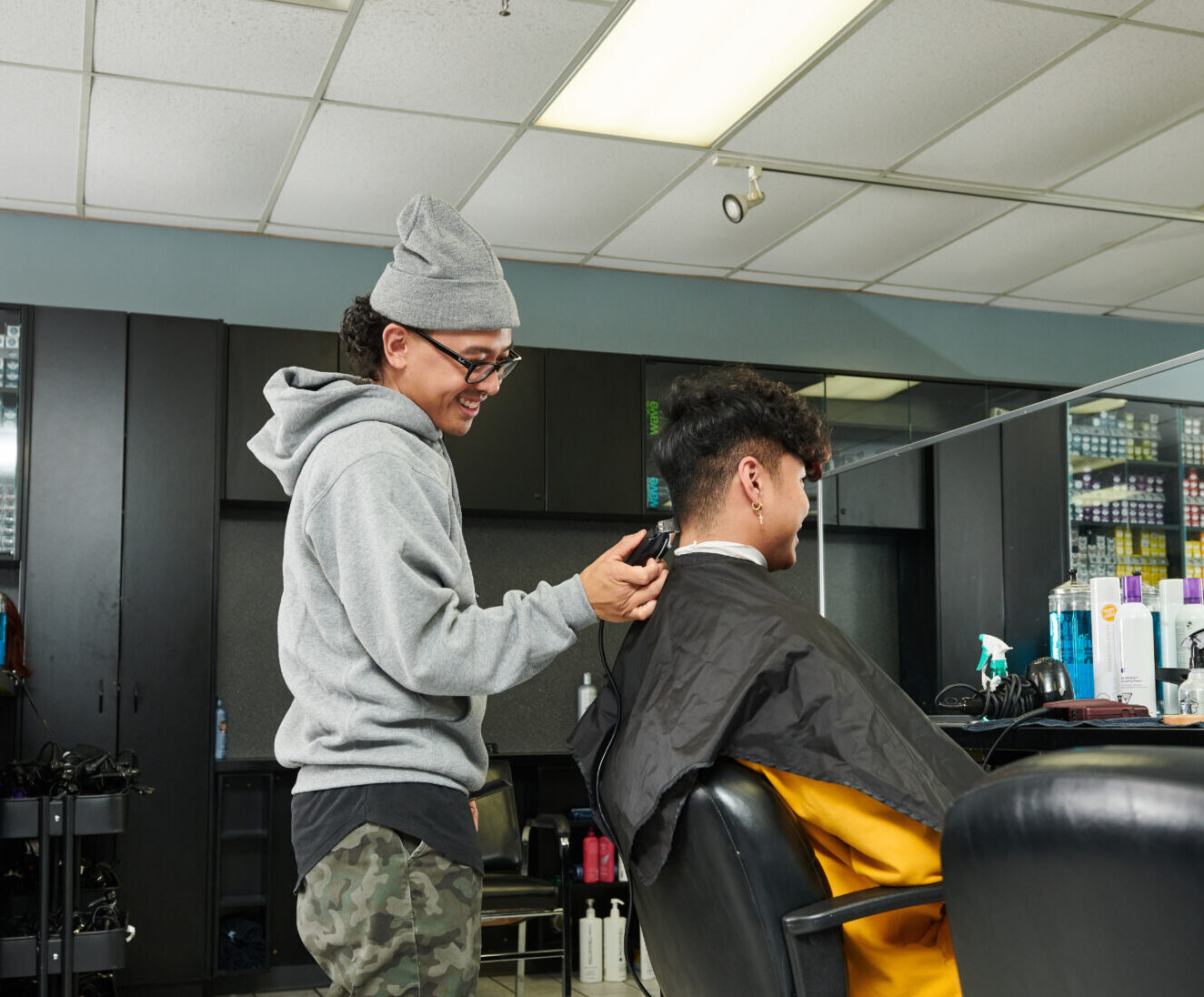 Student cutting hair with a hair clipper
