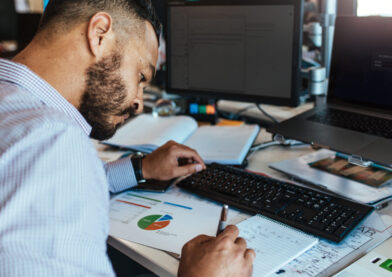 Businessman making notes at his office desk.