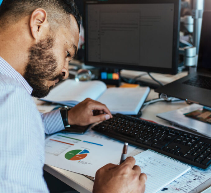 Businessman making notes at his office desk.