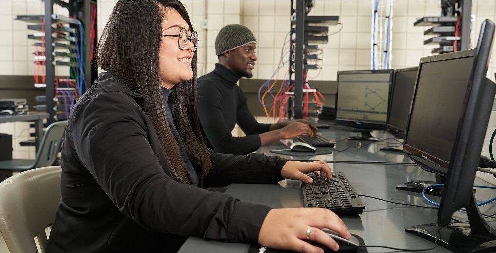 Woman and man on computers in computer lab