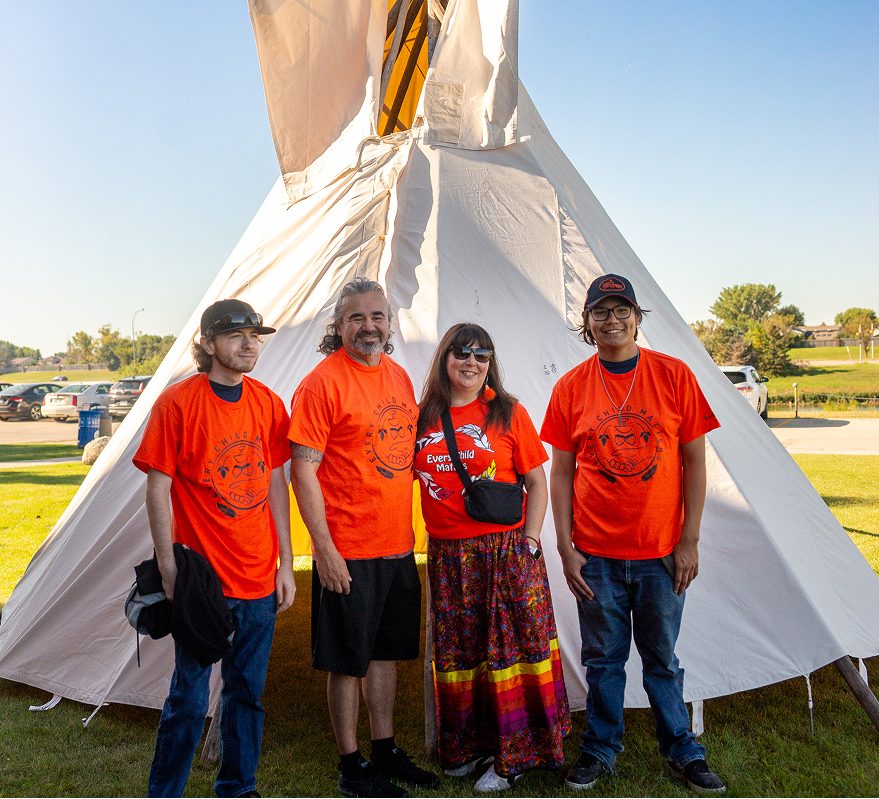 Indigenous students in front of tipi