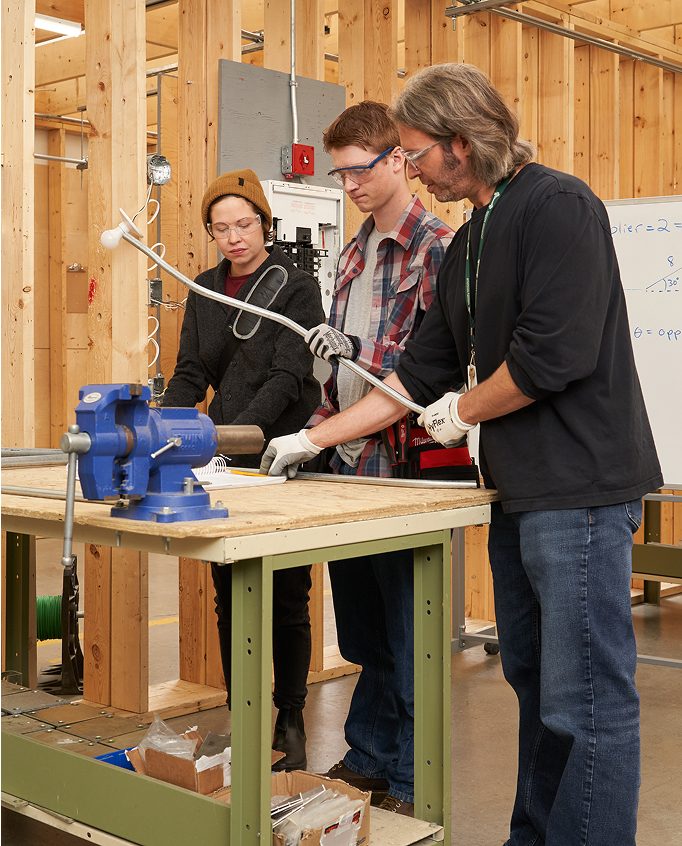 Teacher teaching students in house frame