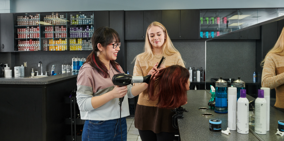 Students in hair salon practicing cutting hair
