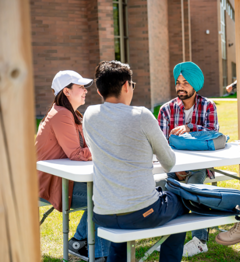 Students sitting outside at a table