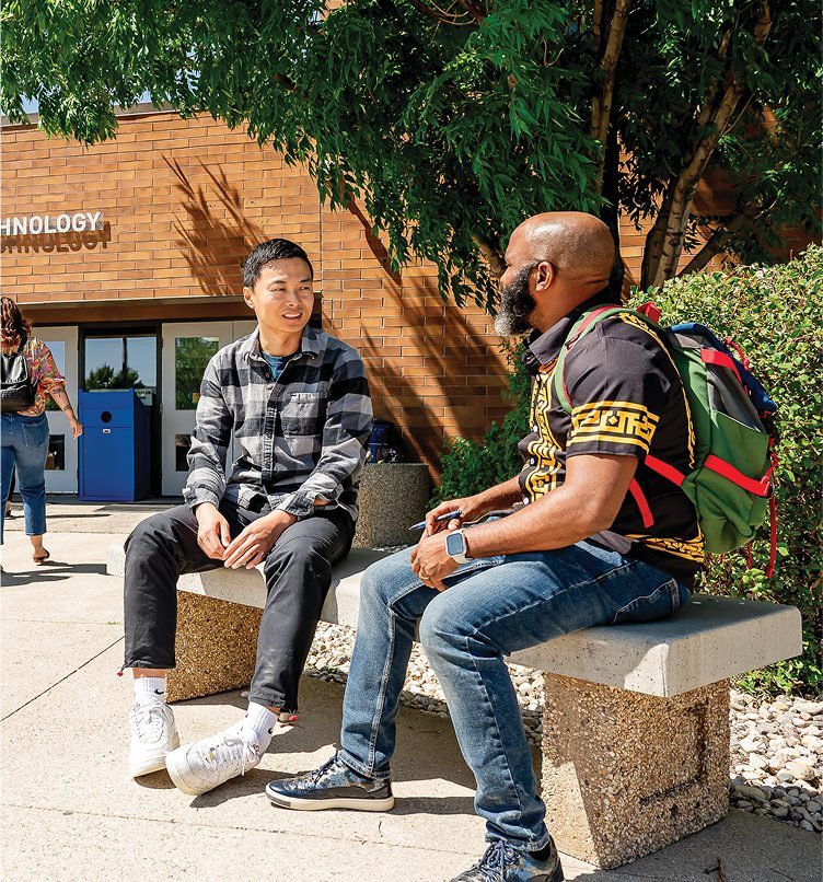students sitting in front of school