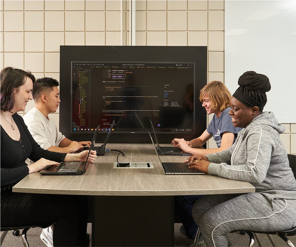 students at desk writing code
